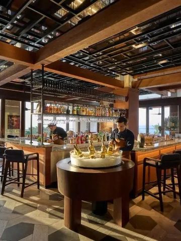 Elegante Hotelbar mit modernen Holzelementen und Blick auf das Meer