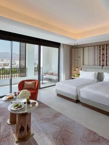 Luxuriöses Hotelzimmer mit zwei Betten, modernem Design und Balkon mit Bergblick