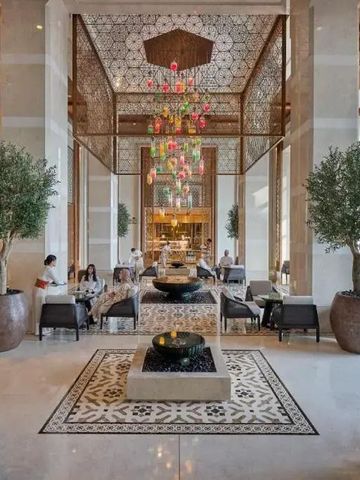 Prächtige Hotellobby mit hohen Decken, modernen Möbeln und stilvollem Kronleuchter