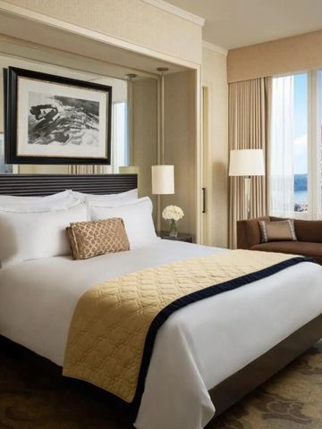 Geräumiges Hotelzimmer mit großem Bett und Blick auf die Stadt