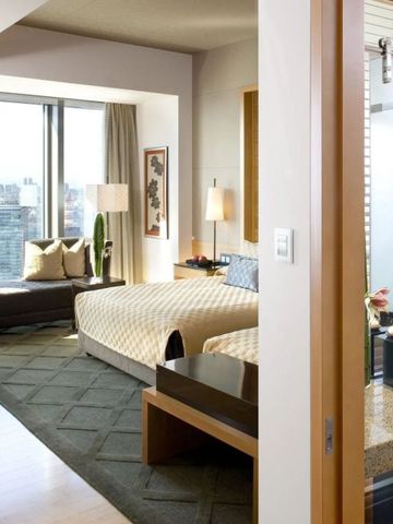 Hotelzimmer mit großen Fenstern und stilvoller Einrichtung sowie Stadtblick