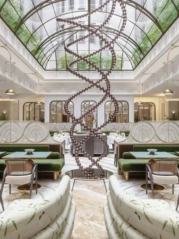 Eleganter Lobbybereich mit Glasdach und kunstvoller Skulptur in modernem Design