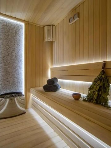 Holzsauna mit kuscheligen Handtüchern und traditionellem Besen