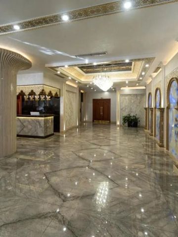 Großzügiger Lobbybereich mit kunstvoller Deckenverzierung und Marmorboden