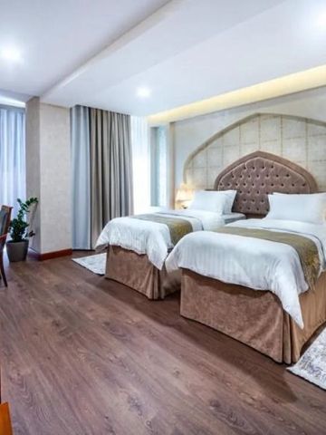 Zwei Einzelbetten im stilvollen und geräumigen Hotelzimmer