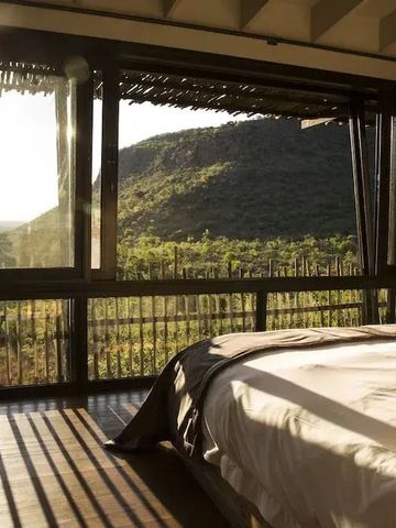 Zimmer mit Panoramafensterblick auf die Berge und Natur bei Sonnenaufgang