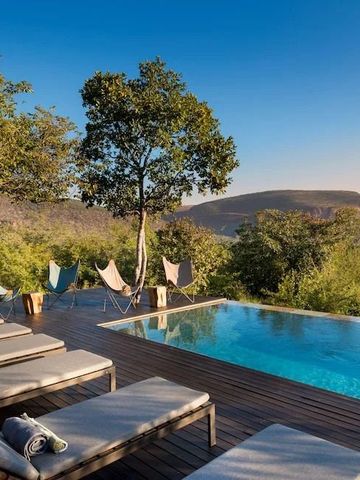 Luxuriöser Infinity-Pool mit Blick auf die afrikanische Savanne bei blauem Himmel