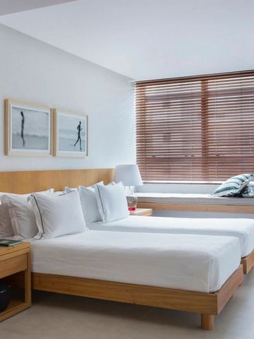 Doppelzimmer mit schlichten Vorhängen und eleganter Einrichtung