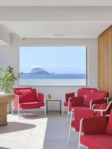 Lounge-Bereich mit roten Sesseln und atemberaubendem Meerblick