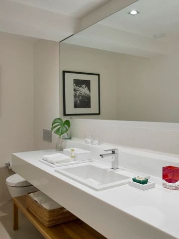 Helles Badezimmer mit großen Spiegeln und minimalistischer Einrichtung