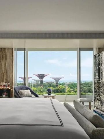 Hotelzimmer mit großen Fenstern und Blick auf Gärten und Stadt