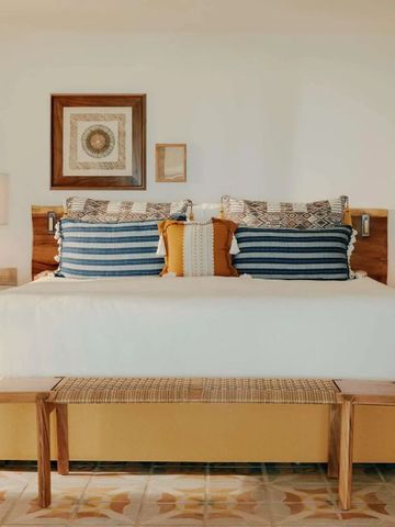 Einladendes Schlafzimmer mit großen Kissen und kunstvoller Wanddekoration