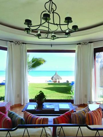 Wohnbereich mit Blick auf den Garten und das Meer durch große Fenster