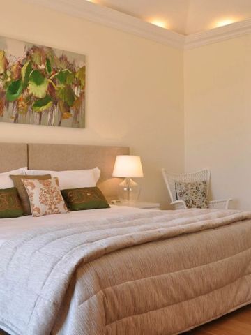 Gemütliches Hotelzimmer mit Doppelbett und moderner Kunst an der Wand