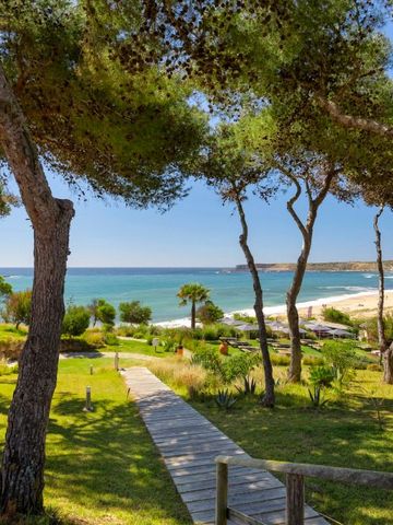 Atemberaubender Blick auf den Strand durch Pinien im Hotelgarten