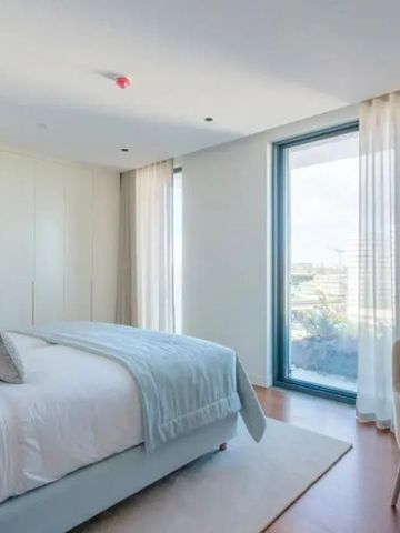 Helles Schlafzimmer mit großem Fenster und Ausblick