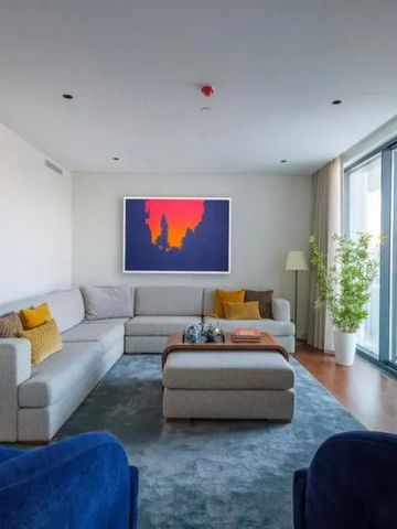 Geräumiges Wohnzimmer mit großen Fenstern und stilvoller Einrichtung.