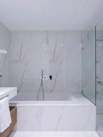 Modernes Badezimmer mit Marmordesign und eleganter Badewanne.