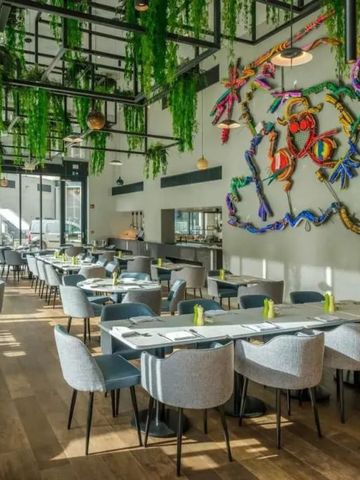 Helles Restaurant mit moderner Dekoration und gemütlichen Sitzgelegenheiten.