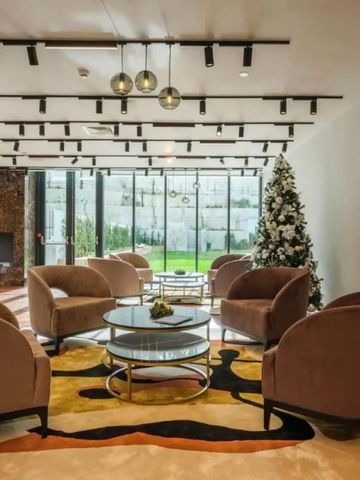 Hotel-Lounge mit eleganten Sesseln, Tischen und dekoriertem Weihnachtsbaum