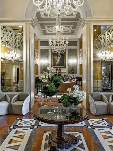 Luxuriöse Lobby mit Marmorboden, Spiegeln und Kronleuchtern in einem Hotel.