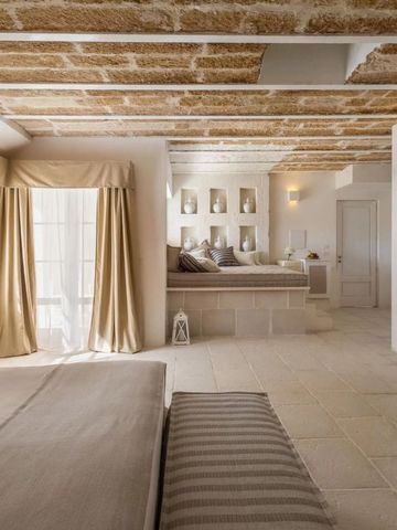 Geräumige Suite mit Steinwänden, großen Fenstern und eleganter Inneneinrichtung.