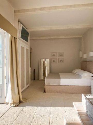 Modernes, stilvolles Schlafzimmer mit großem Doppelbett und Sitzbereich, natürlichem Licht.