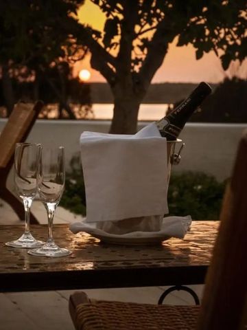 Romantischer Blick auf den Sonnenuntergang von der Terrasse mit Champagner und Gläsern.