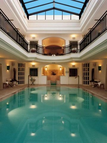 Eleganter Innenpool mit Glasdach und umlaufendem Balkon im Hotel Masseria San Domenico