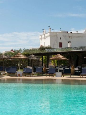 Pool mit Sonnenschirmen im Hintergrund eines historischen Gebäudes