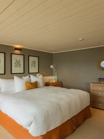 Geräumiges Hotelzimmer mit großem Bett und stilvollen Wanddekorationen