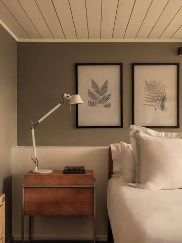 Gemütlicher Schlafbereich mit gerahmten Wandbildern und Nachttischleuchte