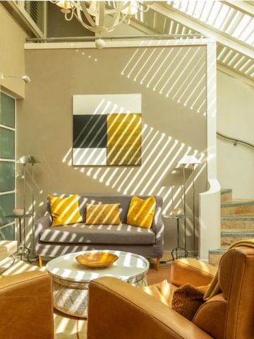 Lichtdurchfluteter Lounge-Bereich mit modernen Möbeln und Kunstwerken