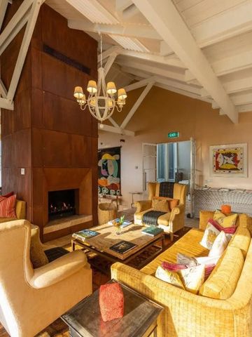 Gemütliche Lounge mit Kamin und stilvollen Möbeln im Hotel Rosewood Matakauri