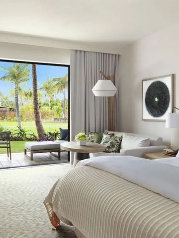 Helles Zimmer mit Doppelbett und Terrasse im Mauna Lani Hotel.