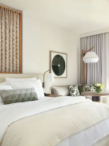 Helles Hotelzimmer mit großem Bett und Balkon mit Meerblick