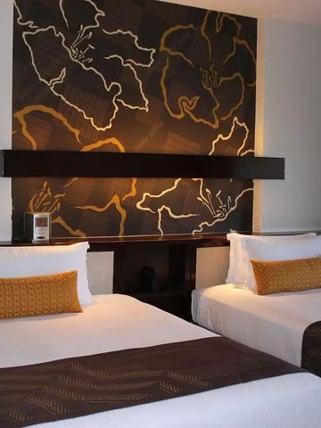 Zwei Einzelbetten in modernem Hotelzimmer mit Kunstwerk an der Wand