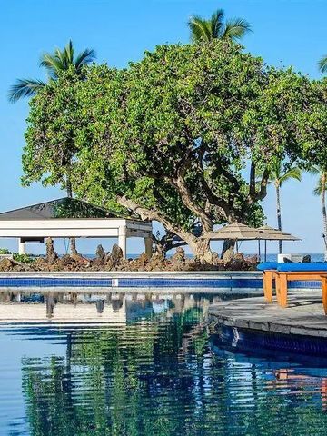 Infinity-Pool mit Blick auf das Meer und tropische Bäume