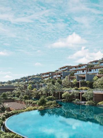 Infinity-Pool mit Blick auf moderne Hotelfassaden am Hang und üppiger Natur