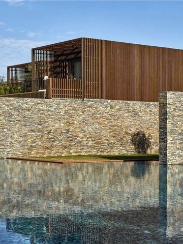 Moderne Villa aus Stein und Holz am Rand eines klaren Pools im MAXX Royal Kemer