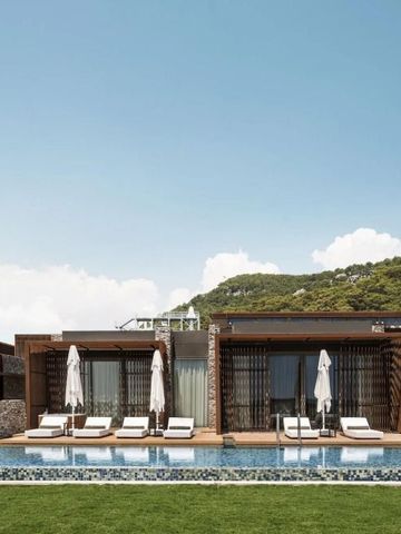 Villa mit Pool und Liegestühlen vor einer bewaldeten Hügellandschaft im MAXX Royal Kemer