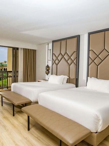 Modernes Hotelzimmer mit zwei Betten und Blick auf den Balkon im Mazagan Beach & Golf Resort