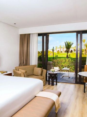 Helles Hotelzimmer mit großen Fenstern und Sitzecke im Mazagan Beach & Golf Resort