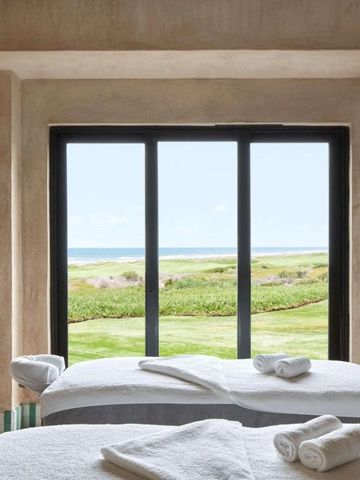 Wellnessraum mit Massagetischen und Ausblick auf die Gartenlandschaft im Mazagan Beach & Golf Resort