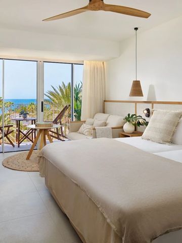 Helles Hotelzimmer mit Balkon und Meerblick, elegant eingerichtet