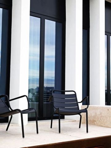 Terrassenbereich mit modernen Stühlen und Glasfassade