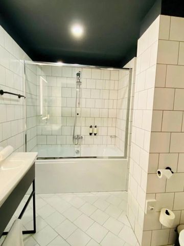 Helles Badezimmer mit Dusch-Badewanne und minimalistischem Design