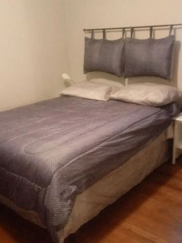 Kompaktes Schlafzimmer mit Doppelbett und blauer Bettwäsche
