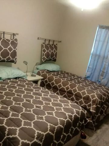 Schlafzimmer mit zwei Einzelbetten und dekorativen Kissen