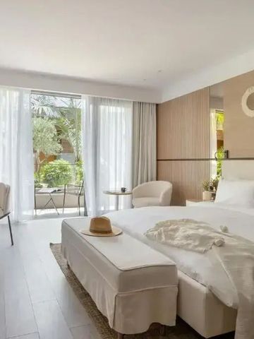 Helles Schlafzimmer mit großen Fenstern und Zugang zu einer Terrasse